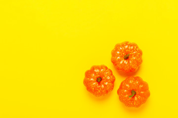 Decorative pumpkins on a yellow background. Halloween concept, harvest, autumn. Flat lay, top view