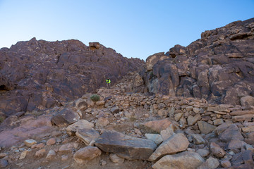 A bearded man on the mountain of Moses with a camera, pilgrimage to the holy places. Nature photographer taking photos in the mountains.