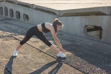 A young slim athletic girl in sportswear with snakeskin prints performs a set of exercises. Fitness...