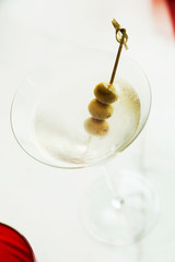 Dry martini with green olives on table