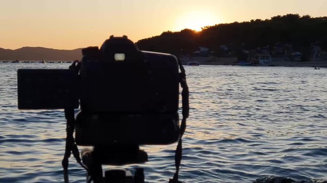 Shooting landscape timelaps with boats in marina bay, sea, colorful sky in golden hours. Taking timelaps video at golden hours on the beach.