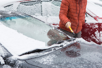 The guy cleans the car from the snow with a brush, Bad snow weather concept