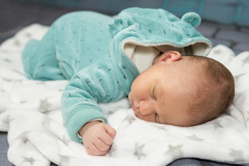 A newborn baby lies on a blanket, studio photo.