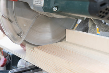 Close-up of a carpenter working with a miter saw. Concept of construction, woodwork, carpentry