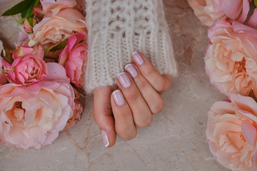 ideally made manicure. Women's hands on the background of flowers