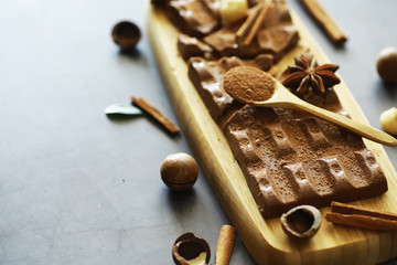 A bar of milk chocolate on the table. Chocolate with nuts and cinnamon.