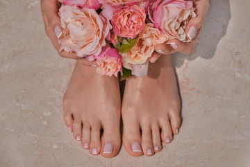 ideally made manicure and pedicure. Women's legs and hands on the background of flowers