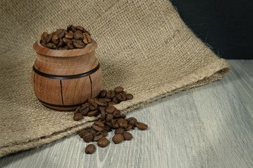 Roasted coffee beans, wooden pot and jute sack