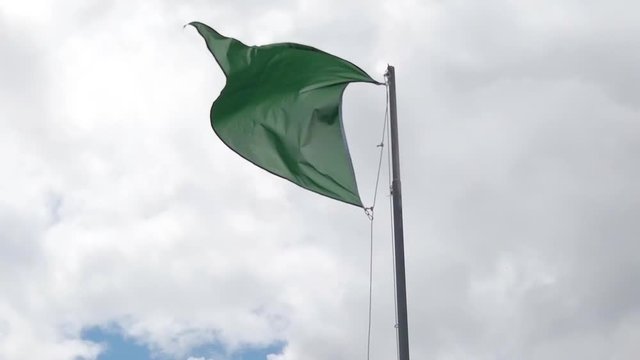 Slow motion of Triangular green flag. A green flag waving authorize bathing in the beach, France