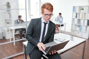 Young Red Haired Businessman Holding Laptop