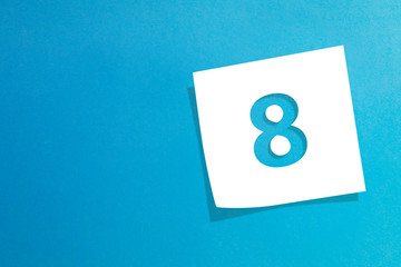 Note paper with number eight on blue background