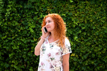 redhead woman with talking with her cellphone