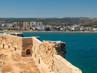 Walls of Maiden's castle or Kizkalesi or Deniz kalesi and view of sea and Kizkalesi town, Mersin province, Turkey