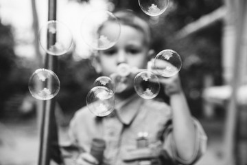 Little boy blowing bubbles. The concept of childhood.Black and white photo