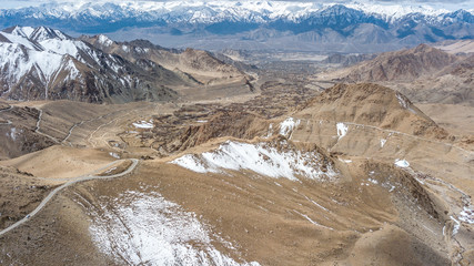 Natural Atmosphere of Leh Ladakh City, Jammu, north of India in Winter. Rock Mountain with Snow cover to Himalayas mountains, one of Highest road in the world. Photo from aerial view by drone.