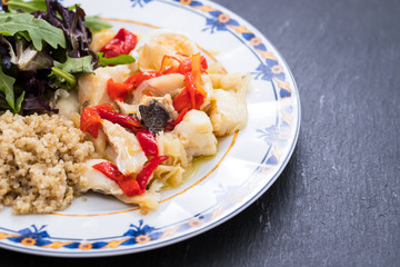 cod fish with quinoa and fresh salad on dish