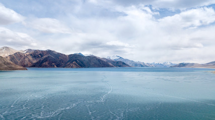 Blue Ice surface of Frozen Lake from drone aerial view at Pangong Lake or Pangong Tso, Tso moriri – Nubra, India. Abstract concept of Cold winter, peaceful and freedom.