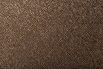 Textural of dark brown background of wavy corrugated paper, closeup.