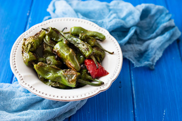 grilled green pepper on white plate on wooden background