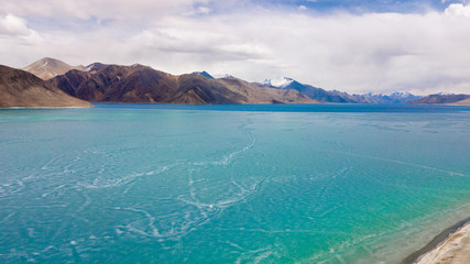 Fototapeta premium Blue Ice surface of Frozen Lake from drone aerial view at Pangong Lake or Pangong Tso, Tso moriri – Nubra, India. Abstract concept of Cold winter, peaceful and freedom.