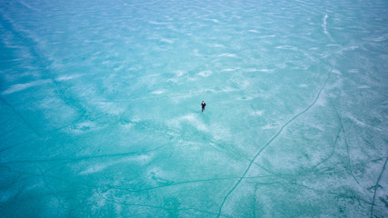 Naklejka premium Man walking on Surface of Frozen Lake from drone aerial view at Pangong Lake or Pangong Tso, Tso moriri – Nubra, India. Abstract concept of Cold winter, peaceful and freedom.