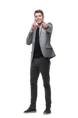 Naklejka premium handsome man talking to a mobile phone and pointing to a copy of the space