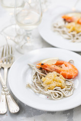 Traditional Spanish food. Gulas with oil and shrimp on white plate.