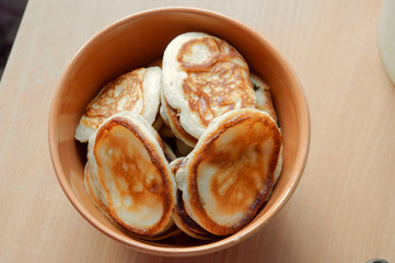 Delicious pancakes in a deep bowl. Pancakes in a brown plate.