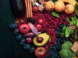 Foods rich in fiber as bread sticks, wheat, white beans, lentils, spinach, nuts, seed, pears, bananas, berries, avocado, plums, eggplant, broccoli, onion, tomatoes, Wooden table as background