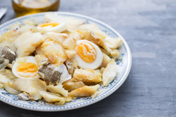 cod fish with onion, eggs and olive oil on dish