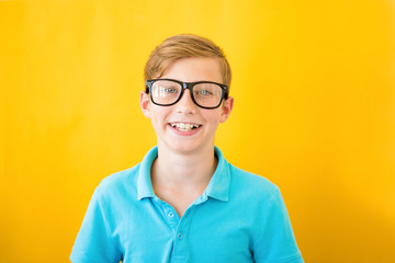 Teenager kid boy squints in myopia correction glasses