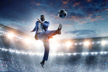 Black businessman in a suit playing footbal © Sergey Nivens
