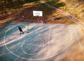 Father and son playing basketball in the park
