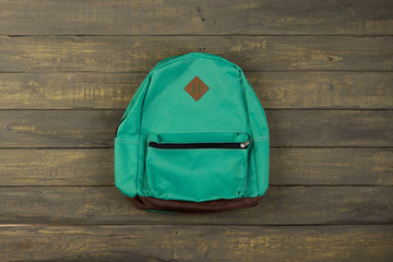 Back to school concept - blue backpack on wooden backgroung,