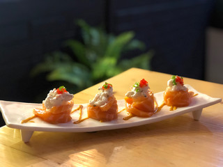 salmon sushi rolls on the white dish with cafe light background. Japanese food.