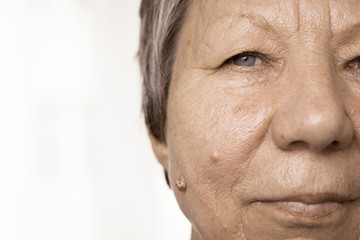 Obraz na płótnie Canvas Elderly pensioner female half face portrait closeup