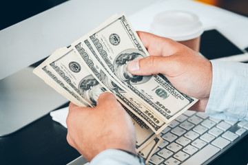Caucasian hands counting dollar banknotes