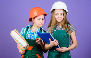 Little kids in helmet with tablet and roller. small girls repairing together in workshop. school project. Labor day. 1 may. Foreman inspector. Repair. Ready to repair your everything