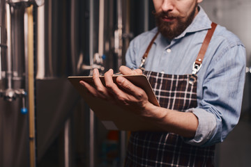 Close up of a brewery worker checking the beer storage.