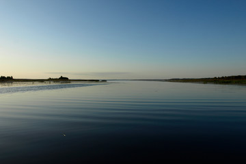 Scenic sunrise panorama view, morning fog on lake, misty reflection in steaming water, Latvia