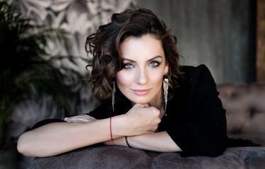 Beautiful woman in an elegant outdoor dress posing alone, sitting in a chair