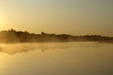 sunrise above a river on foggy summer morning, the sky reflections in the water,  misty reflection in steaming water, Salaca river, Latvia 