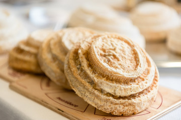 Typical Italian Montebore cheese wheels on wooden cutting board