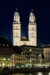 Fototapeta na wymiar Zürich Grossmünster und Limmatquai bei Nacht, Grossmünster beleuchtet, dunkelblauer Nachthimmel, Spiegelungen in der Limmat