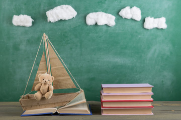 Education is a journey concept, toy boat and books on the chalkboard background, inspiration for a...