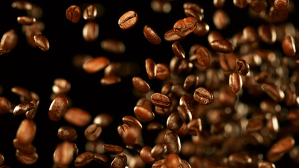 Fresh roasted coffee beans flying in the air