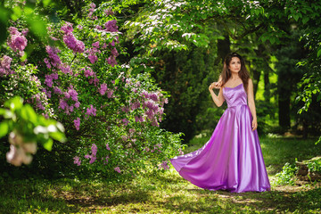 Obraz na płótnie Canvas Pretty woman posing near the blooming tree. Spring park