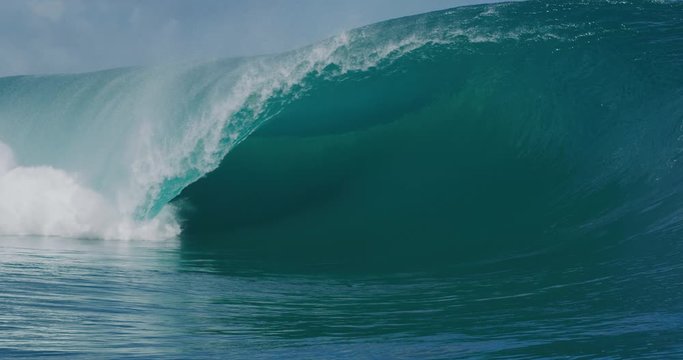 Huge blue ocean wave breaking with lots of power in slow motion, most epic wave on the planet
