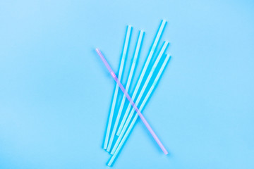 Blue cocktail straws on a color background.