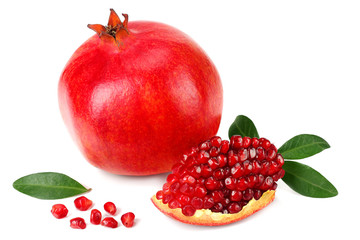 piece of pomegranate with seeds and green leaves isolated on a white background.